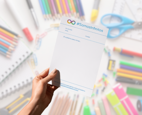 Una mano sujeta un papel sobre un fondo de lápices de colores